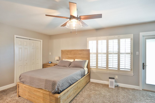 carpeted bedroom with baseboards, a closet, and a ceiling fan