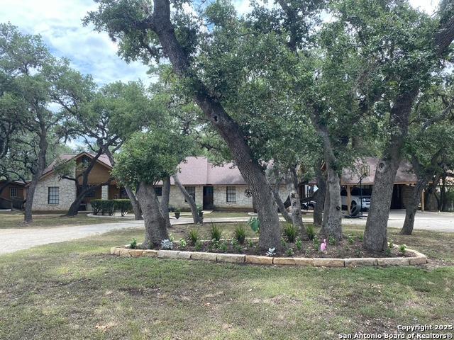 9516 Geronimo Oaks, San Antonio, TX 78254 - view of property hidden behind natural elements with stone siding