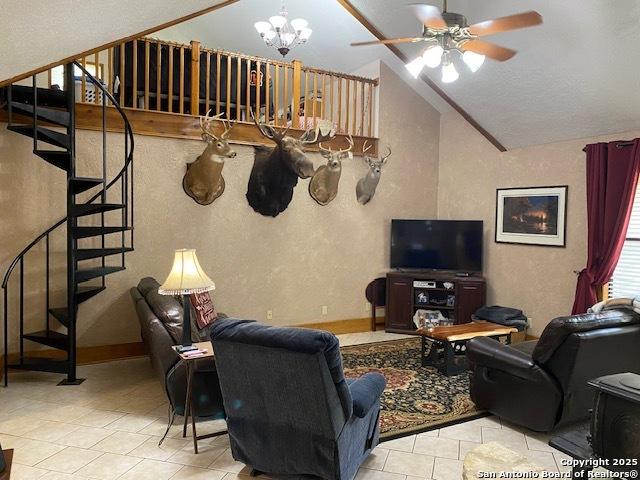 9516 Geronimo Oaks, San Antonio, TX 78254 - tiled living area with lofted ceiling, stairs, a ceiling fan, a chandelier, and a textured wall