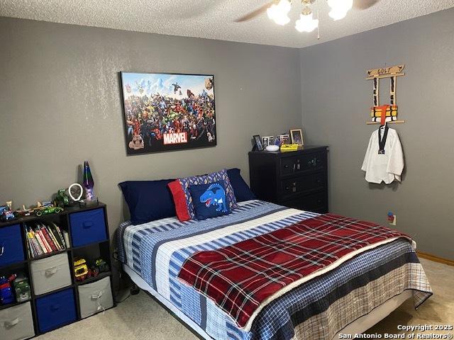 9516 Geronimo Oaks, San Antonio, TX 78254 - carpeted bedroom featuring ceiling fan and a textured ceiling