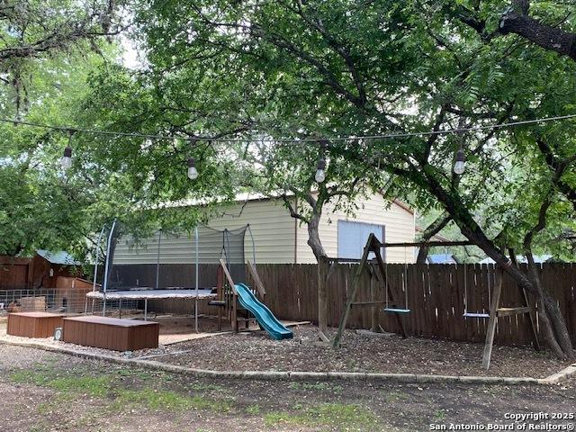 9516 Geronimo Oaks, San Antonio, TX 78254 - view of jungle gym featuring a trampoline and fence