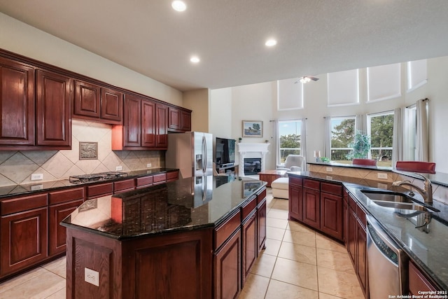 18211 Branson Fls, San Antonio, TX 78255 - kitchen featuring stainless steel appliances, tasteful backsplash, a sink, a glass covered fireplace, and recessed lighting