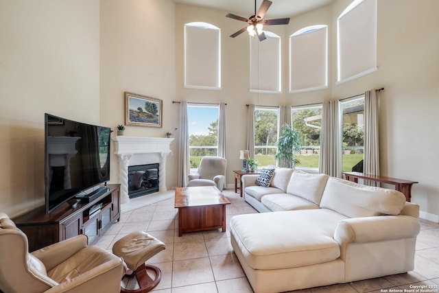 18211 Branson Fls, San Antonio, TX 78255 - living area featuring a high ceiling, a fireplace, a ceiling fan, light tile patterned floors, and baseboards