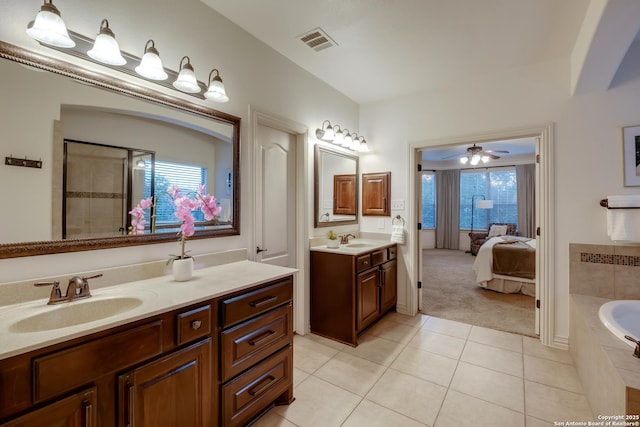 bathroom featuring connected bathroom, a ceiling fan, tile patterned floors, two vanities, and a relaxing tiled tub