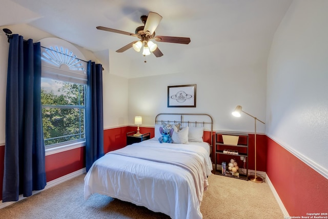 carpeted bedroom featuring lofted ceiling and a ceiling fan