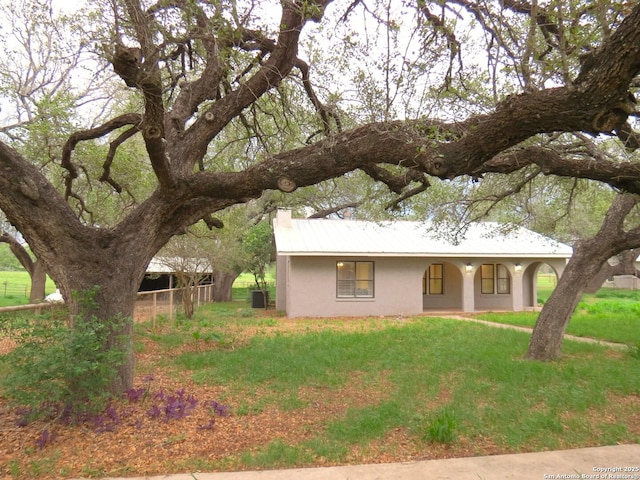 ranch-style home featuring stucco siding and a front yard