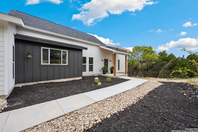 410 Compass Rose, Canyon Lake, TX 78133 - view of exterior entry with board and batten siding and roof with shingles