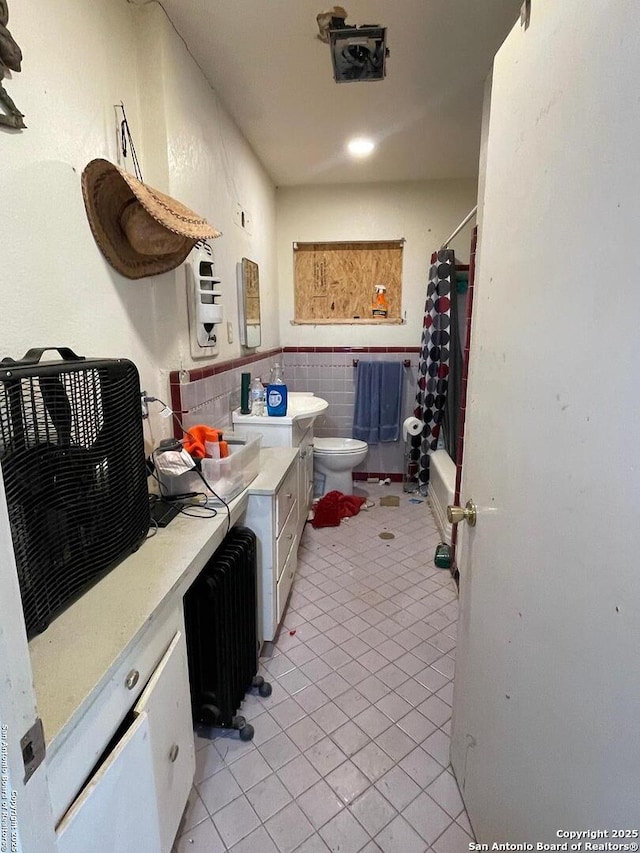 314 Veda Mae, San Antonio, TX 78216 - bathroom featuring tile patterned flooring, radiator heating unit, toilet, a wainscoted wall, and shower / bath combo with shower curtain