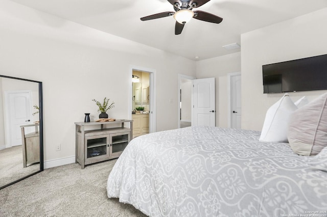 carpeted bedroom featuring baseboards, ensuite bath, and ceiling fan