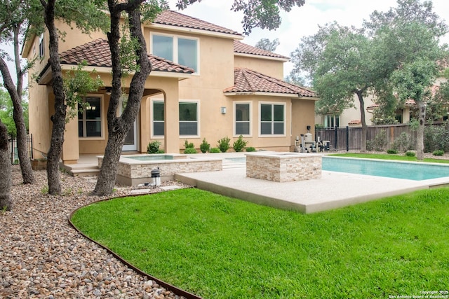 back of property with stucco siding, a tiled roof, a patio, and an in-ground hot tub