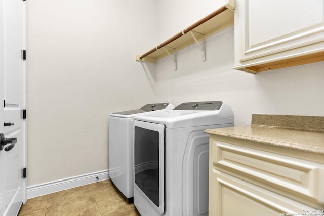 laundry room featuring washer and dryer, baseboards, and cabinet space