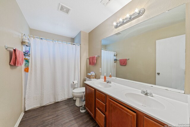 13303 Sunset Rainbow, San Antonio, TX 78245 - full bathroom featuring wood finished floors, toilet, and double vanity