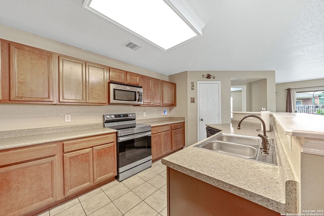 13303 Sunset Rainbow, San Antonio, TX 78245 - kitchen featuring appliances with stainless steel finishes, a sink, light tile patterned flooring, a center island with sink, and light countertops