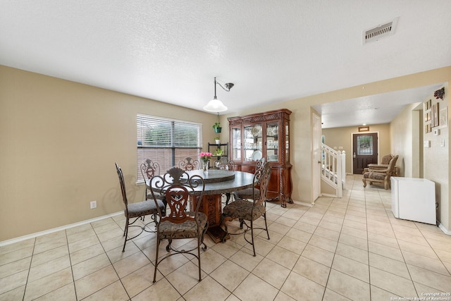 13303 Sunset Rainbow, San Antonio, TX 78245 - dining space featuring light tile patterned floors, baseboards, a textured ceiling, and stairway
