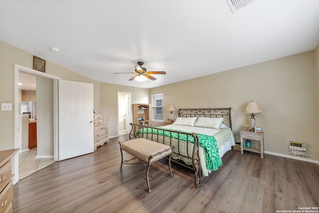 13303 Sunset Rainbow, San Antonio, TX 78245 - bedroom featuring wood finished floors, baseboards, a ceiling fan, and stainless steel refrigerator with ice dispenser