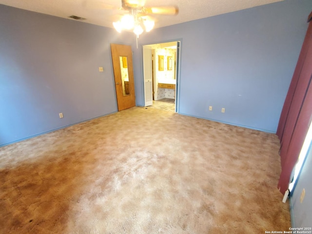 unfurnished bedroom featuring carpet flooring, ensuite bathroom, and ceiling fan
