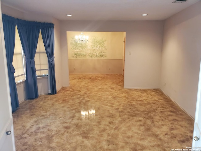 empty room featuring a chandelier, carpet flooring, recessed lighting, and baseboards