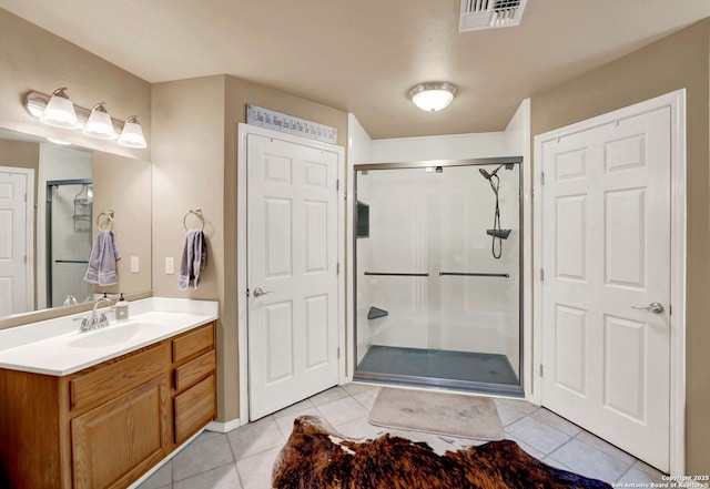 full bath featuring a stall shower, tile patterned floors, and vanity