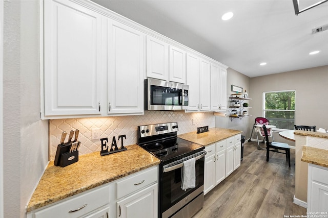 kitchen with stainless steel appliances, backsplash, white cabinetry, and recessed lighting
