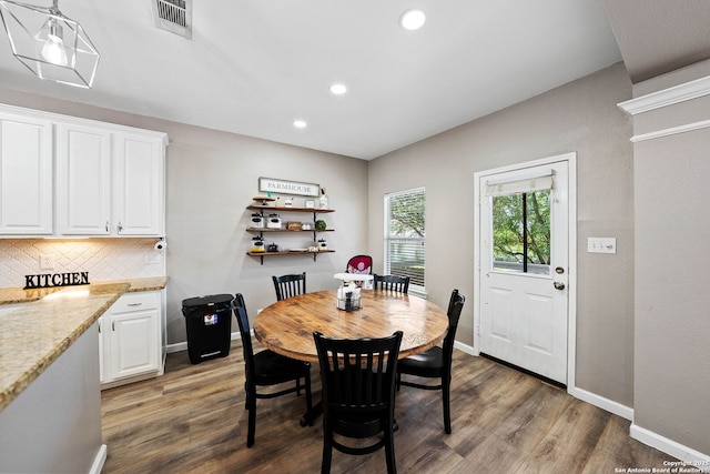 dining room featuring wood finished floors, recessed lighting, and baseboards