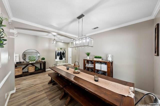 dining room featuring crown molding, wood finished floors, and baseboards