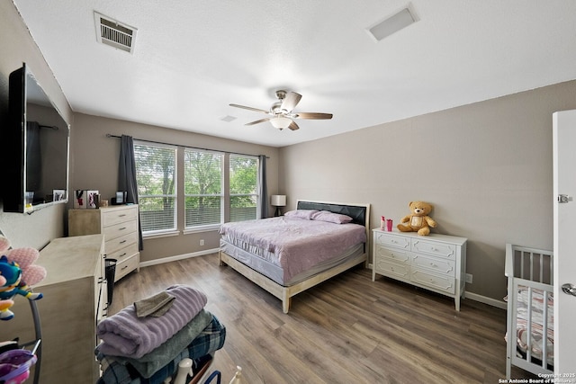 bedroom featuring wood finished floors, baseboards, and ceiling fan