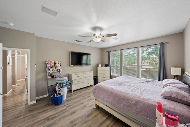 bedroom featuring wood finished floors, baseboards, and a ceiling fan
