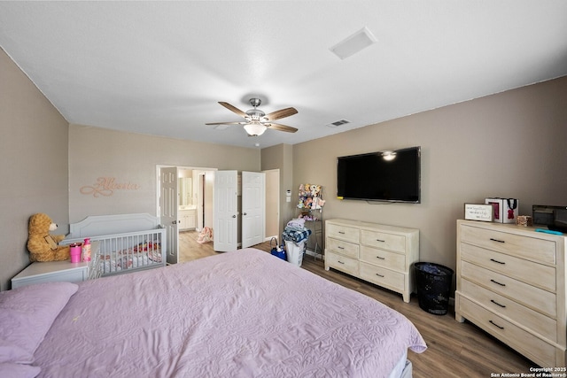 bedroom with wood finished floors, ceiling fan, and ensuite bathroom