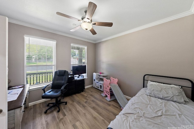 bedroom featuring a desk, ornamental molding, wood finished floors, baseboards, and a ceiling fan