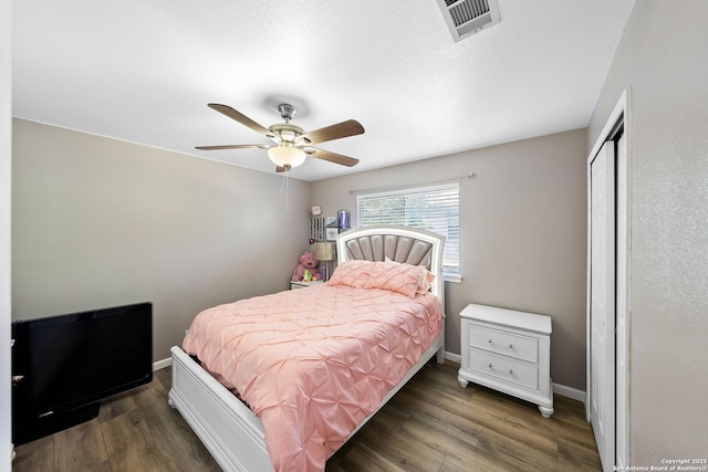 bedroom with wood finished floors, baseboards, a closet, and a ceiling fan
