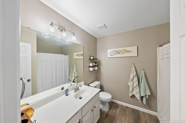 bathroom featuring wood finished floors, vanity, toilet, and baseboards