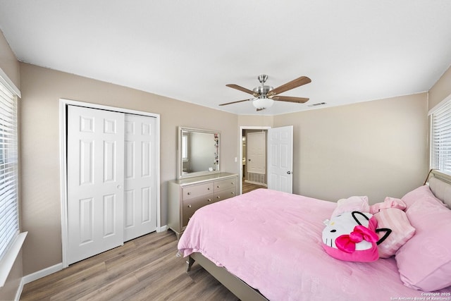 bedroom featuring light wood-style floors, a closet, baseboards, and a ceiling fan