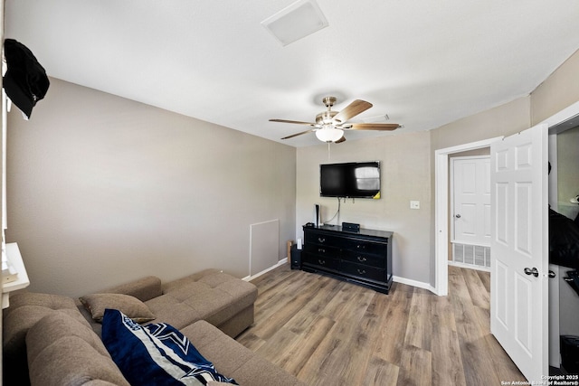 living room featuring wood finished floors, a ceiling fan, and baseboards