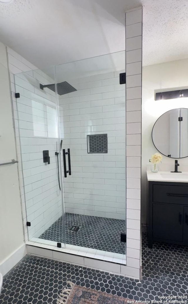 2114 S Trinity St, San Antonio, TX 78207 - bathroom with tile patterned flooring, baseboards, vanity, a shower stall, and a textured ceiling