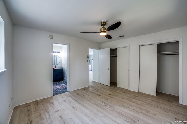 2114 S Trinity St, San Antonio, TX 78207 - unfurnished bedroom with two closets, wood finished floors, ensuite bath, baseboards, and ceiling fan