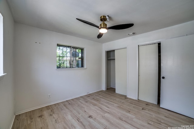 2114 S Trinity St, San Antonio, TX 78207 - unfurnished bedroom with multiple closets, light wood finished floors, ceiling fan, and baseboards