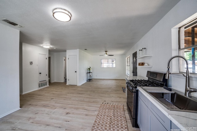 2114 S Trinity St, San Antonio, TX 78207 - kitchen featuring gas stove, a sink, healthy amount of natural light, a ceiling fan, and a textured ceiling