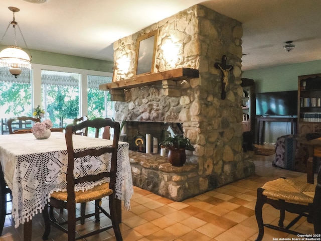 6719 State Highway 55, Uvalde, TX 78801 - dining room with tile patterned flooring and a stone fireplace