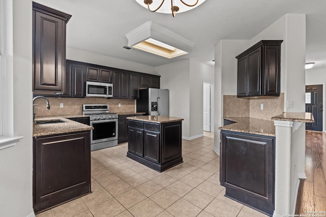 25836 Stone Cyn, San Antonio, TX 78260 - kitchen featuring appliances with stainless steel finishes, light stone countertops, tasteful backsplash, and a peninsula