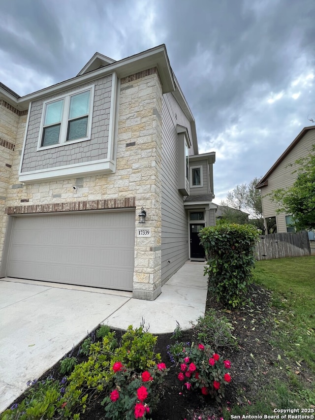 17339 Brachetto, San Antonio, TX 78247 - view of front of house featuring stone siding, a garage, fence, and driveway