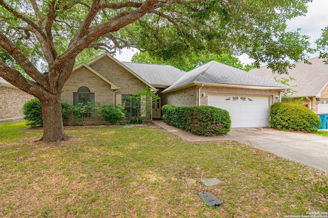 ranch-style home with a garage, brick siding, concrete driveway, a front lawn, and roof with shingles