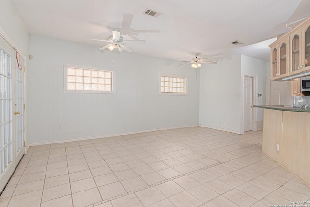 spare room featuring ceiling fan, light tile patterned flooring, and baseboards