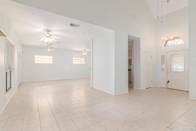 foyer featuring a chandelier, ceiling fan, light tile patterned flooring, and baseboards