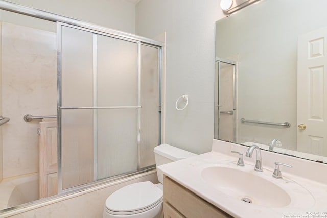 bathroom featuring toilet, enclosed tub / shower combo, and vanity
