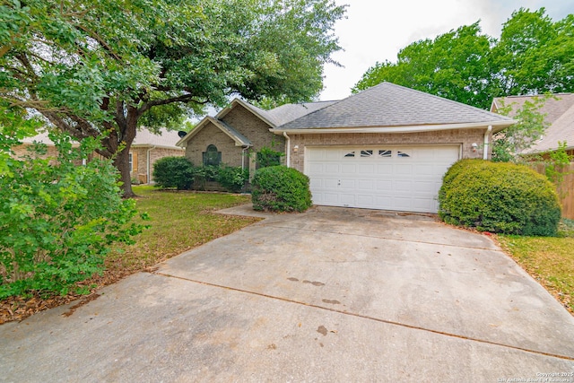 view of front of property with driveway, brick siding, a front lawn, and an attached garage