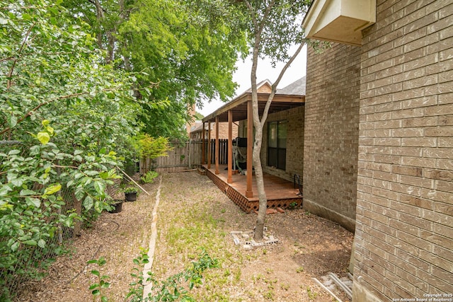 view of yard featuring fence and a deck