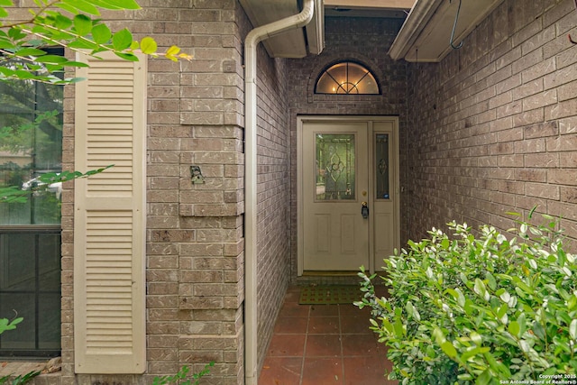 view of exterior entry featuring brick siding