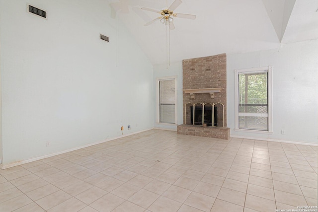 unfurnished living room with a ceiling fan, high vaulted ceiling, light tile patterned floors, baseboards, and a brick fireplace
