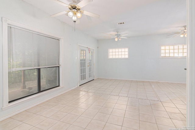 empty room featuring a ceiling fan, light tile patterned flooring, and baseboards