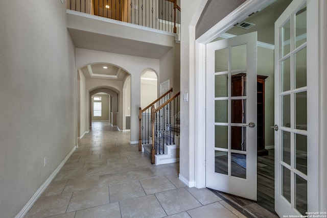 12418 Maverick Rnch, San Antonio, TX 78254 - foyer featuring arched walkways, french doors, stone tile floors, baseboards, and stairs